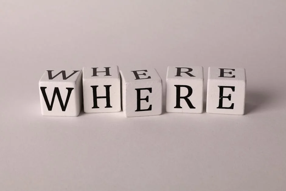Close-up of white blocks with letters spelling 'WHERE' against a plain background.