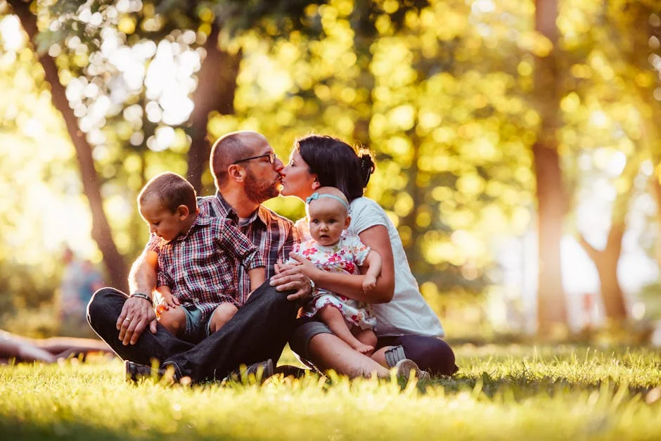 Family of four enjoying a sunny day outdoors, capturing a loving moment in nature.